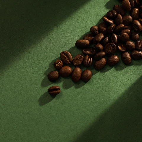 Coffee beans spilled across green card